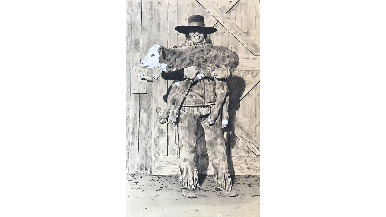 young cowboy holding a newborn calf