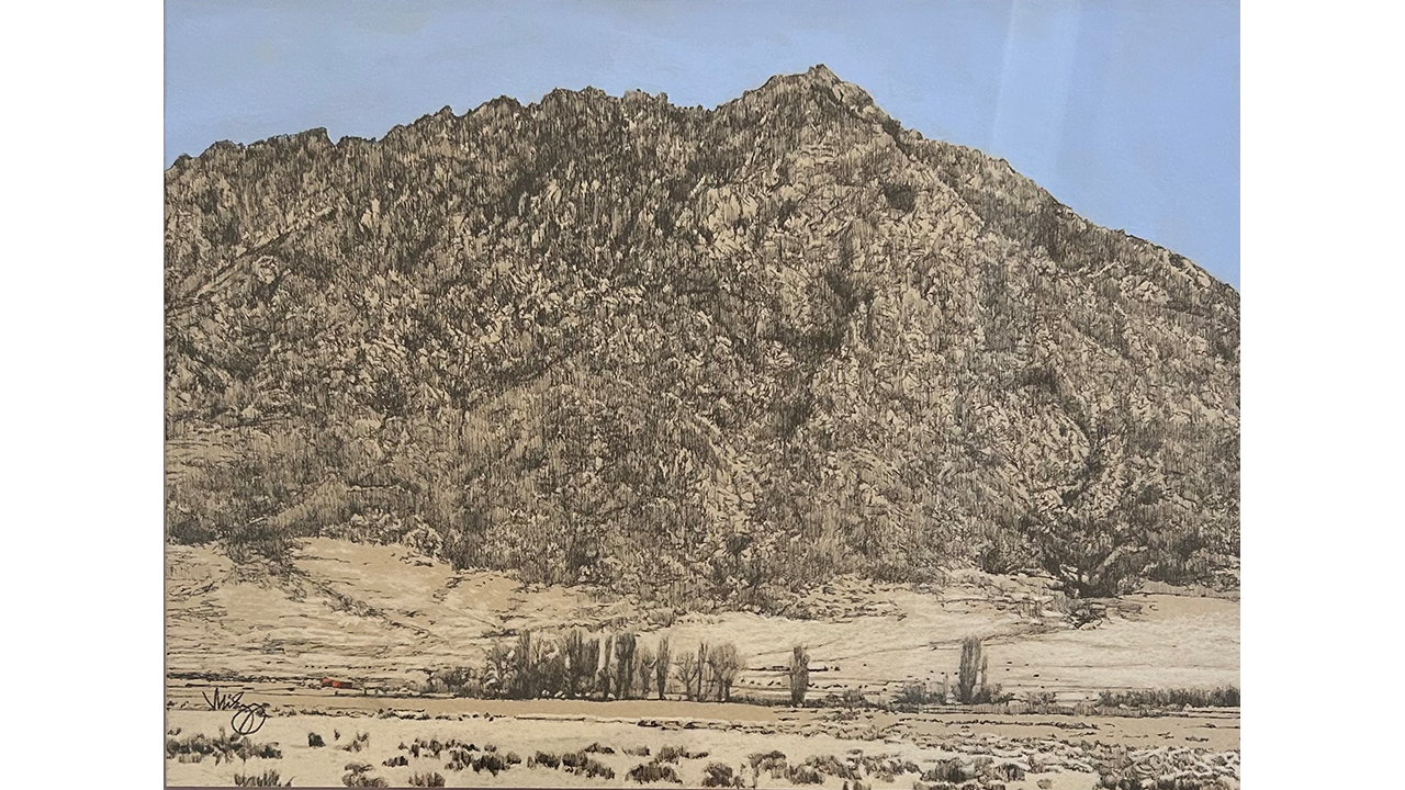 High desert landscape with small red barn and trees in the distance